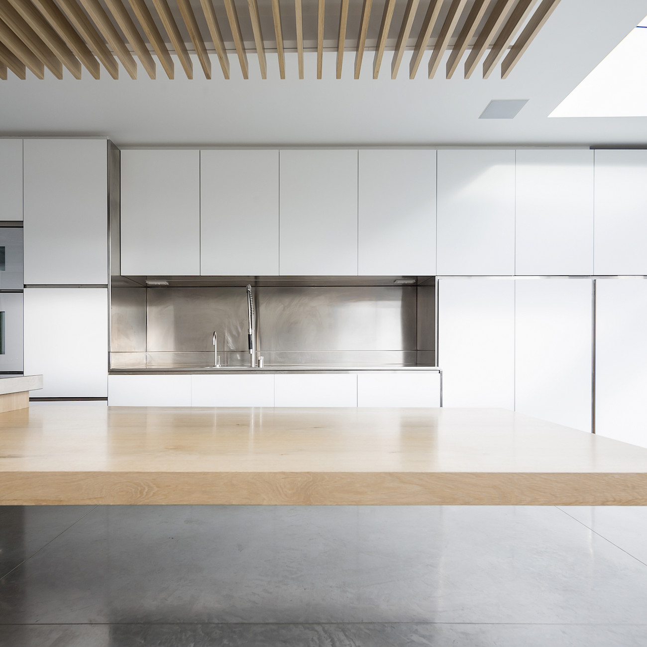 GC House in Fulham by inaki leite design. Bespoke design for kitchen with oak cantilever dining and mate white cabinets